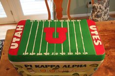 a cake in the shape of a football field on top of a table with chairs