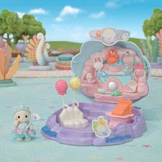 a toy playset in the shape of a princess castle with her doll and accessories