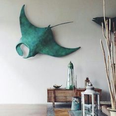 a living room filled with furniture next to a wall mounted stingfish on the wall