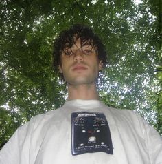 a man standing in front of some trees with an electronic device on his chest and head