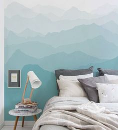 a bedroom with a bed, nightstand and wallpaper in shades of blue and grey