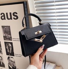 The Emes Shop bag details afaux leather feeland a luxurious design. Features a simple clasp. small handle. andcrossbodybag design.MATERIAL:100% Vegan LeatherMEASUREMENTS:H" X W"X D" 17cm X 12cm X 7cm 6.7in X 4.7in X 2.7in Faux Leather Top Handle Bag With Hasp Closure, Top Handle Faux Leather Shoulder Bag With Metal Hardware, Faux Leather Shoulder Bag With Metal Hardware, Faux Leather Top Handle Shoulder Bag With Metal Hardware, Elegant Faux Leather Crossbody Flap Bag, Faux Leather Crossbody Satchel With Hasp Closure, Elegant Crossbody Satchel With Single Handle, Elegant Single Handle Satchel For Office, Elegant Single Handle Office Satchel