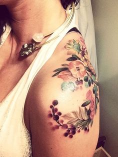 a woman with a flower tattoo on her arm and shoulder is looking at the camera