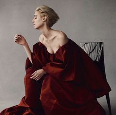 a woman in a red dress sitting on a chair