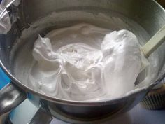 a metal bowl filled with whipped cream on top of a stove