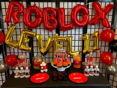 a table topped with balloons and desserts next to a sign that says roblox levi