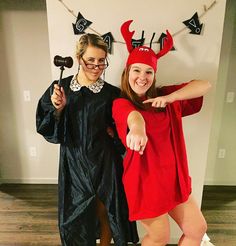 two women dressed up as devil and witch pointing at the camera while standing next to each other