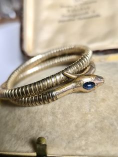 Elegant bangle made of doublè with a movable core so that the bracelet adjusts to the size of your breathing. On its head, the snake wears a sapphire cabochon in a great blue. Unfortunately, the condition is no longer so good, but in my opinion, this really gives the bracelet character. Dimensions head approx. 25 x 7 mm Diameter unstretched approx. 5.3 cm All items in my shop are sold according to §25a UStG differential taxation. An invoice prepared by Etsy is included with every purchase. If yo Antique Gold Snake-shaped Jewelry, Antique Snake-shaped Yellow Gold Jewelry, Vintage Snake-shape Jewelry For Formal Occasions, Vintage Yellow Gold Snake Jewelry, Antique Gold Snake Ring For Formal Occasions, Serpent Art, Snake Bangle, Sapphire Cabochon, Bangles Making