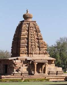 an intricately carved stone structure in the middle of a park