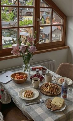 a table topped with plates of food next to a window