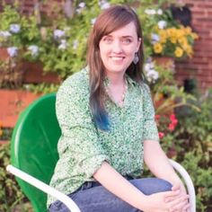 a woman sitting in a green chair outside