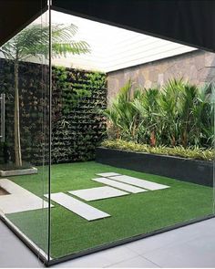 an outdoor area with artificial grass and plants