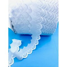 two rolls of white lace on blue background