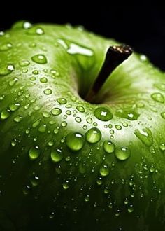 an apple with water drops on it is shown in close up view, showing the green color