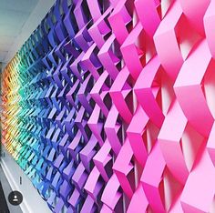 an office wall with many different colored origami pieces on it