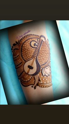 a tattoo on the leg of a woman with a guitar and music notes painted on it