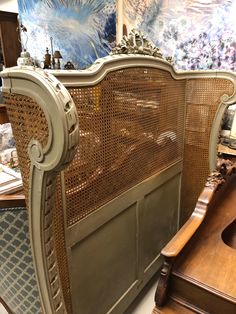 an antique bed frame with wooden slats and carvings on the headboard is shown