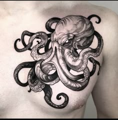 an octopus tattoo on the chest is shown in black and grey ink, with intricate details