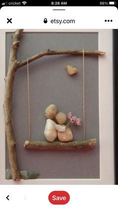 a photo frame with some rocks on it and a tree branch hanging from the side