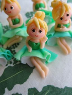 some little toy figurines sitting on top of a green and white table cloth