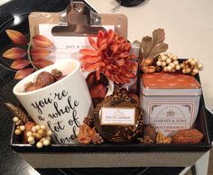 an assortment of items in a gift box on a table with a name tag and tags