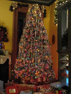 a decorated christmas tree in a living room with presents on the floor next to it