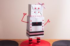 a cardboard robot standing on top of a wooden table