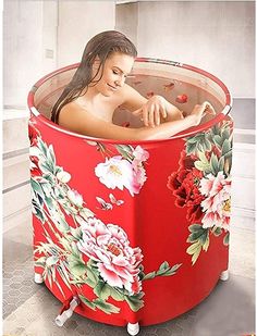 a woman in a red tub with flowers painted on the side and sides, sitting inside