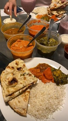 a plate full of food with rice, sauces and other foods on the table