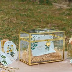 a table topped with a glass box filled with cards