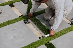 a man is cutting grass with scissors on the ground