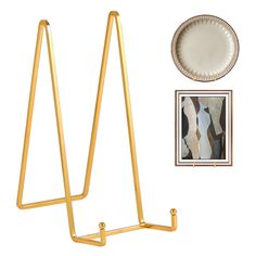 there is a gold metal stand with pictures on it and a plate next to it