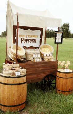 an old fashioned popcorn stand with wooden barrels