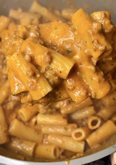 a pot filled with pasta and sauce on top of a stove