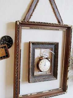 there is a frame with an alarm clock hanging on the wall next to a key