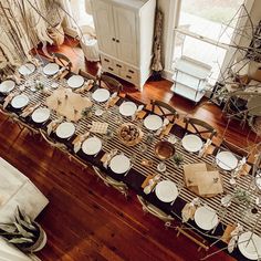 an overhead view of a dining room table set with place settings and napkins on it