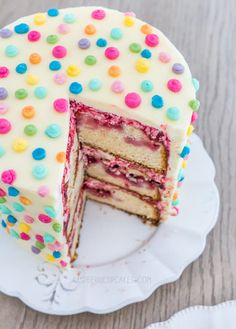 a cake with white frosting and multicolored sprinkles on it