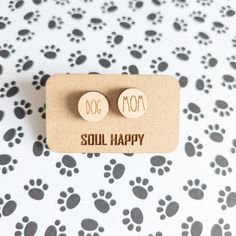 small wooden earrings with words on them sitting on a card that says, dog mom soul happy