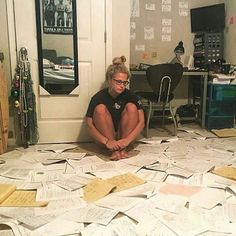 a woman sitting on the floor surrounded by lots of papers and post - it notes