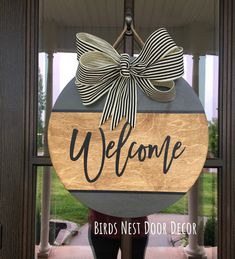 a wooden welcome sign with a bow on it's front door and the words, birds nest door decor