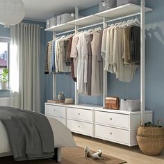 a bedroom with blue walls and white furniture