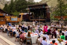 a group of people sitting at tables in front of a stage set up for an event