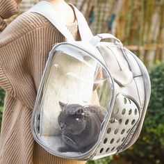 a woman carrying a backpack with a cat in it