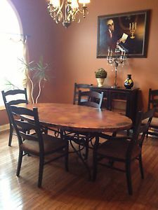 a dining room table with four chairs and a chandelier hanging from the ceiling