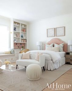 a bedroom with white furniture and pink accents