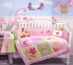 a baby crib bedding set with pink and green flowers on the bedspread