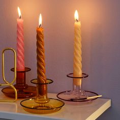 three lit candles sitting on top of a table