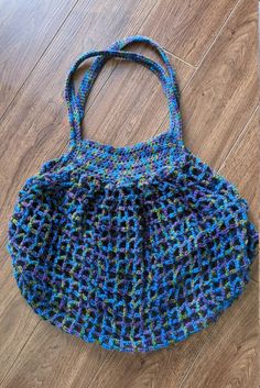 a crocheted purse sitting on top of a wooden floor