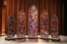 four stained glass windows sitting on top of a stage