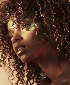 a woman with curly hair and glasses on her face